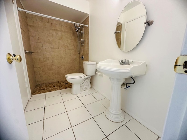 bathroom with tiled shower, tile patterned flooring, and toilet