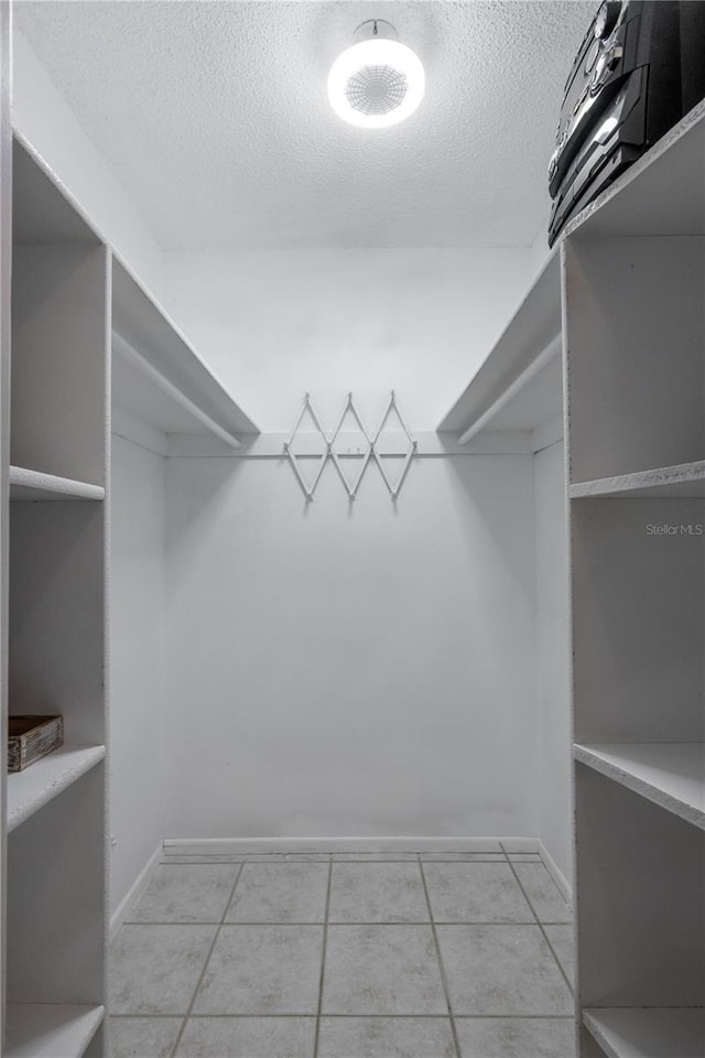 walk in closet with light tile patterned floors