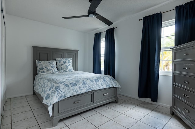 tiled bedroom with ceiling fan and multiple windows