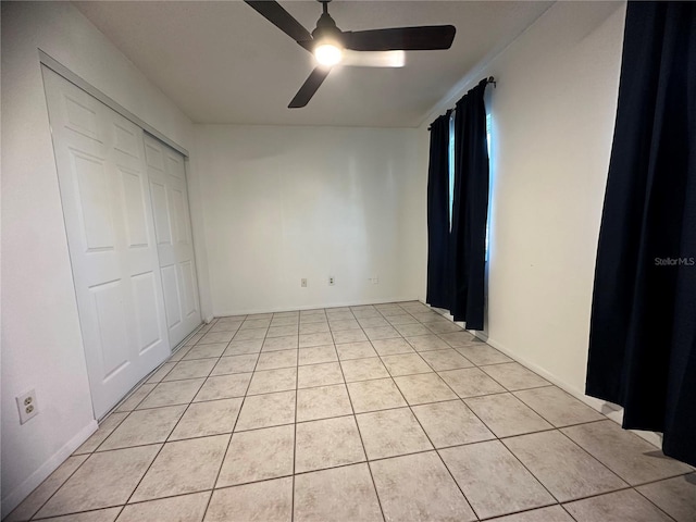 unfurnished bedroom featuring light tile patterned floors, a closet, and ceiling fan