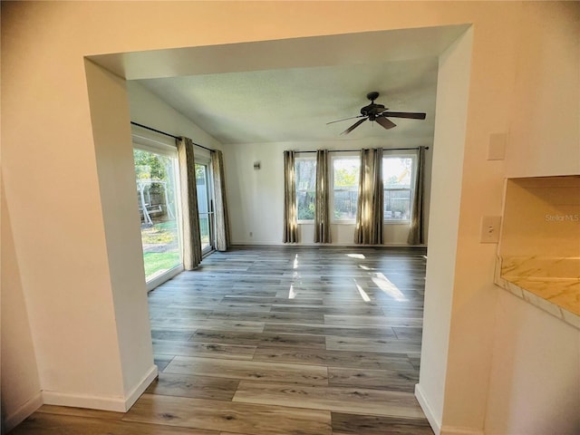 interior space with wood-type flooring, vaulted ceiling, and ceiling fan