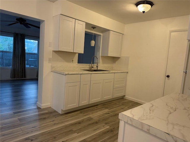 kitchen featuring pendant lighting, dark hardwood / wood-style flooring, white cabinetry, and sink