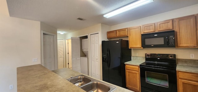 kitchen featuring sink, stacked washer and clothes dryer, and black appliances