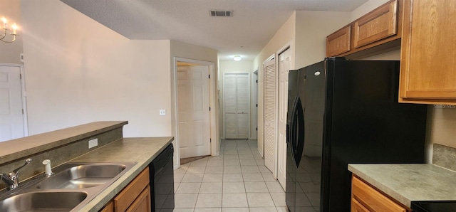 kitchen with black appliances, light tile patterned floors, sink, and a textured ceiling