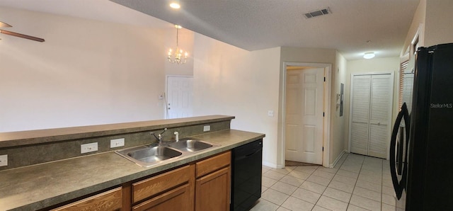 kitchen featuring sink, hanging light fixtures, a textured ceiling, light tile patterned floors, and black appliances