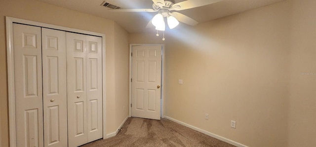 unfurnished bedroom featuring carpet flooring, ceiling fan, and a closet