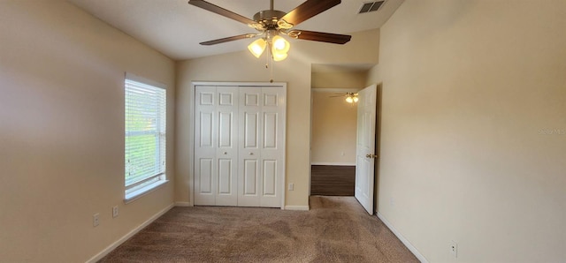 unfurnished bedroom with carpet, ceiling fan, a closet, and vaulted ceiling