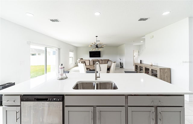 kitchen with sink, gray cabinets, a center island with sink, and stainless steel dishwasher