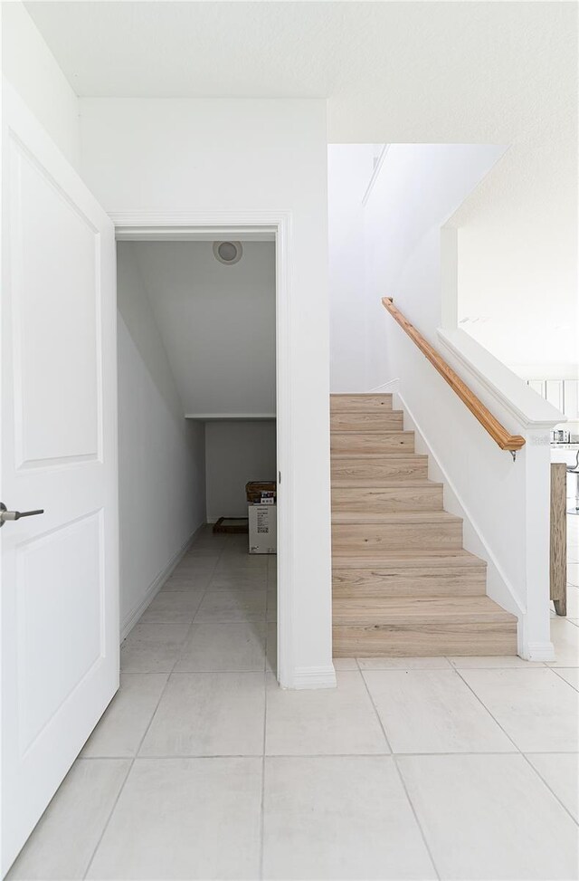 stairs featuring light tile floors