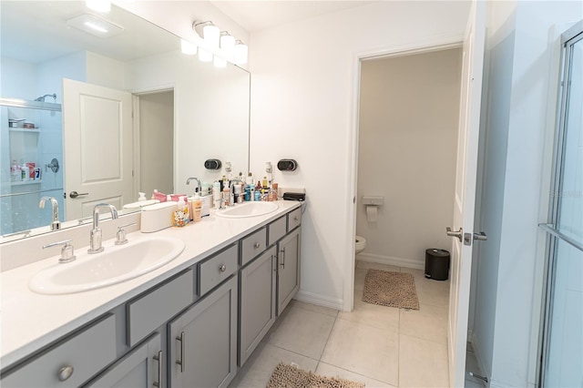 bathroom featuring tile flooring, double sink, toilet, and large vanity