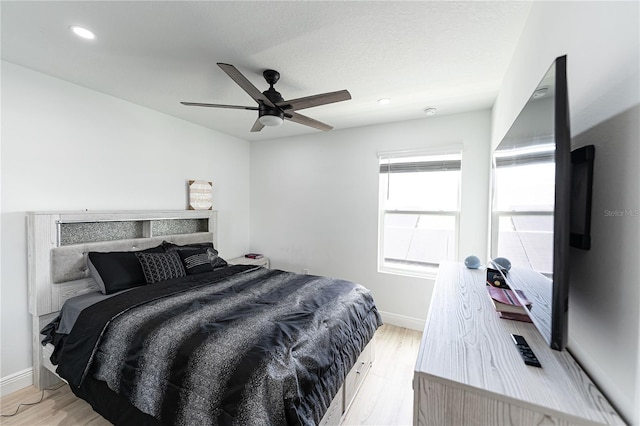 bedroom with ceiling fan and light wood-type flooring