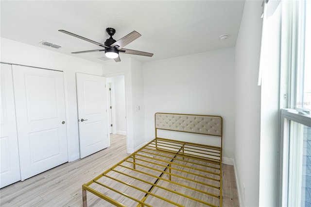 bedroom featuring ceiling fan, light hardwood / wood-style floors, and a closet