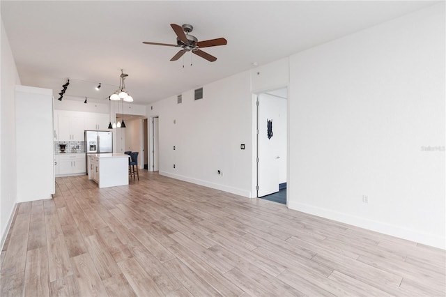 unfurnished living room with ceiling fan and light hardwood / wood-style flooring