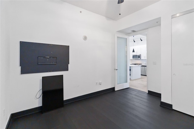 unfurnished living room featuring dark hardwood / wood-style flooring and ceiling fan