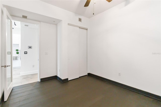 spare room with dark wood-type flooring and ceiling fan