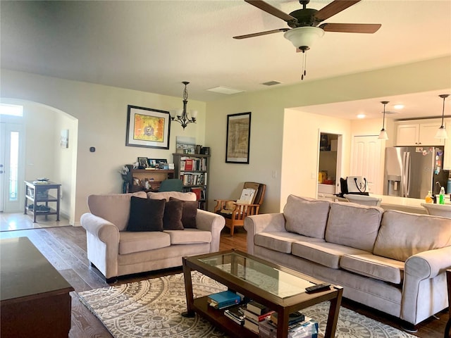 living room featuring dark hardwood / wood-style floors and ceiling fan with notable chandelier