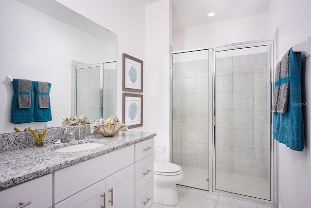 bathroom featuring toilet, vanity, tile patterned floors, and an enclosed shower