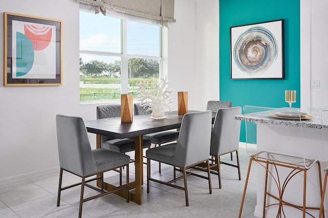 dining area with light tile patterned flooring and baseboards