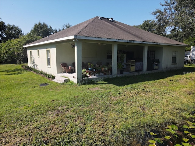 back of house featuring ceiling fan, a lawn, and a patio