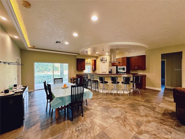 dining space with a textured ceiling and light tile flooring