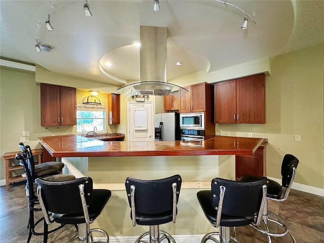 kitchen with island range hood, rail lighting, tile floors, sink, and appliances with stainless steel finishes