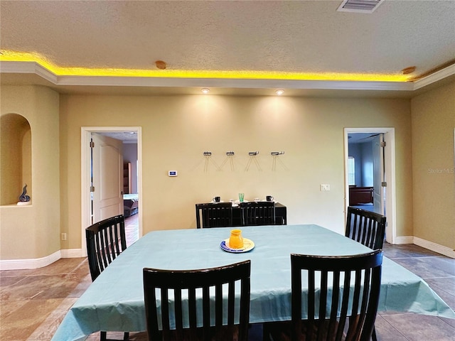 dining room featuring tile floors and a textured ceiling