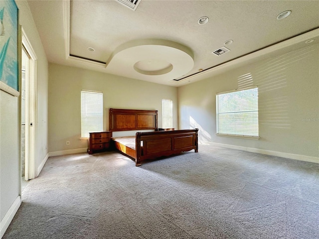 unfurnished bedroom featuring a tray ceiling and carpet flooring