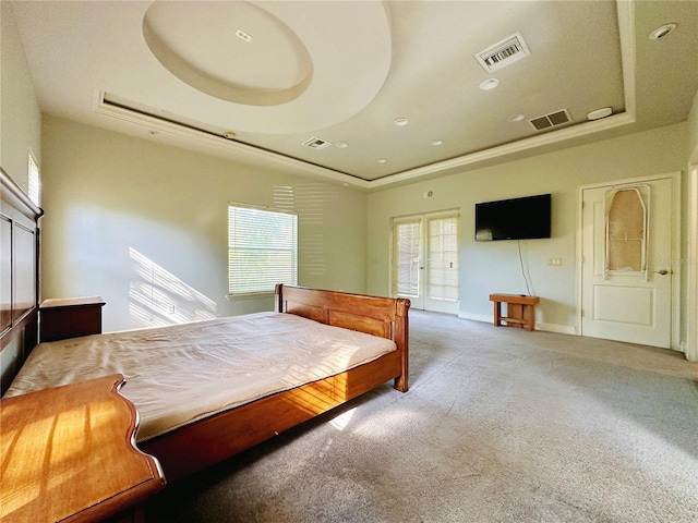 bedroom with carpet, a raised ceiling, and french doors