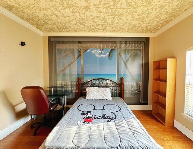 bedroom with ornamental molding and wood-type flooring