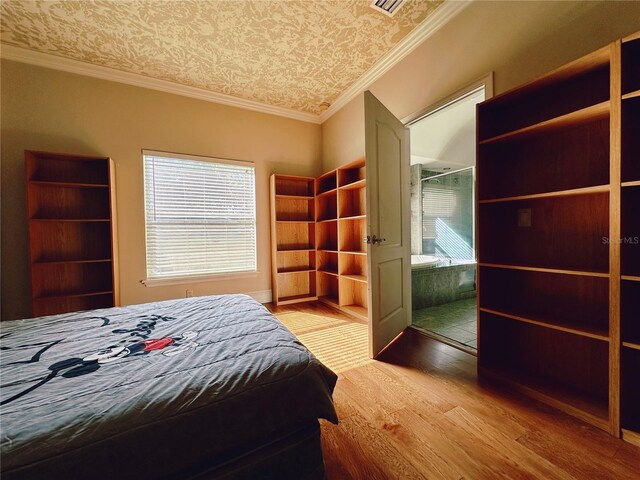 unfurnished bedroom featuring a closet, hardwood / wood-style flooring, and crown molding