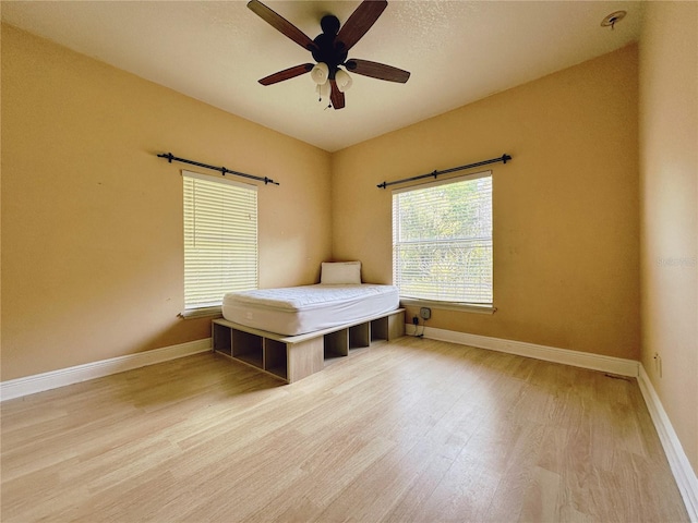 unfurnished bedroom featuring wood-type flooring and ceiling fan