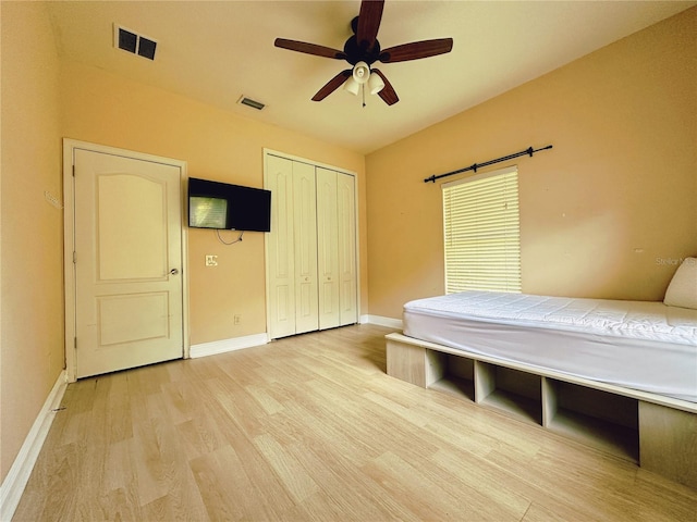 unfurnished bedroom featuring ceiling fan, a closet, and light wood-type flooring