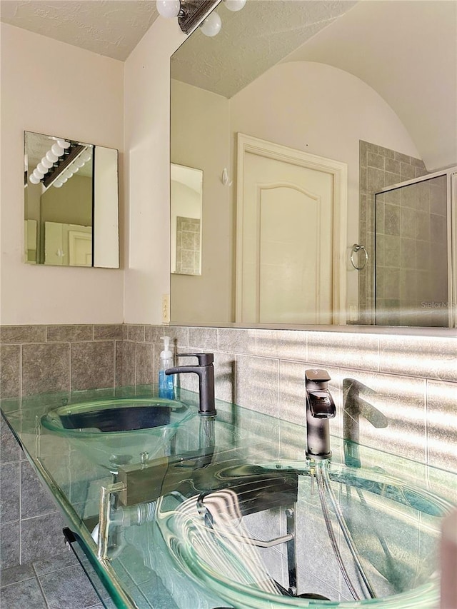 bathroom featuring shower with separate bathtub, sink, tasteful backsplash, and tile floors