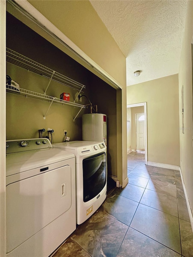 washroom featuring tile flooring, hookup for a washing machine, a textured ceiling, electric water heater, and separate washer and dryer