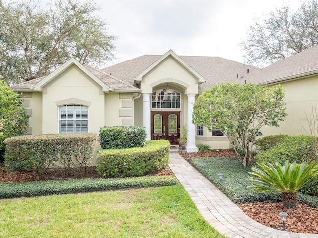 single story home with french doors and a front lawn