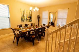 dining area with light tile floors and an inviting chandelier