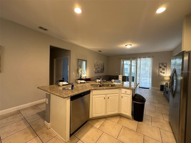 kitchen with light tile patterned flooring, appliances with stainless steel finishes, sink, white cabinets, and light stone countertops