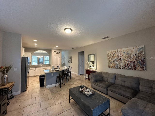 living room featuring a textured ceiling and light tile patterned floors