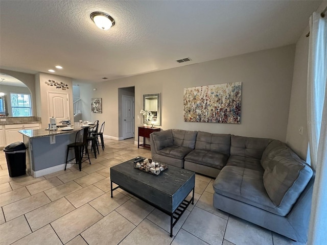 living room featuring light tile patterned floors and a textured ceiling