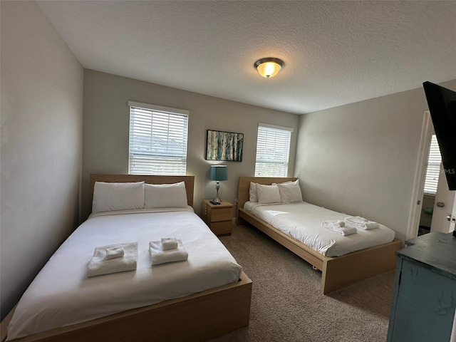 bedroom featuring dark carpet and a textured ceiling