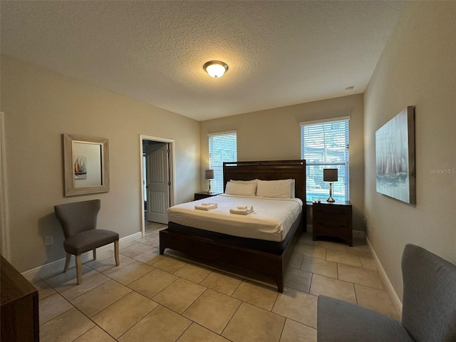 bedroom featuring light tile patterned floors and a textured ceiling