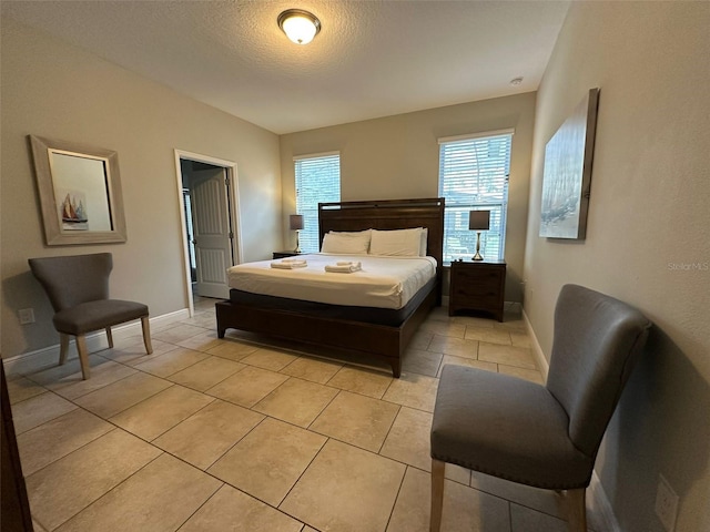 bedroom with light tile patterned floors and a textured ceiling