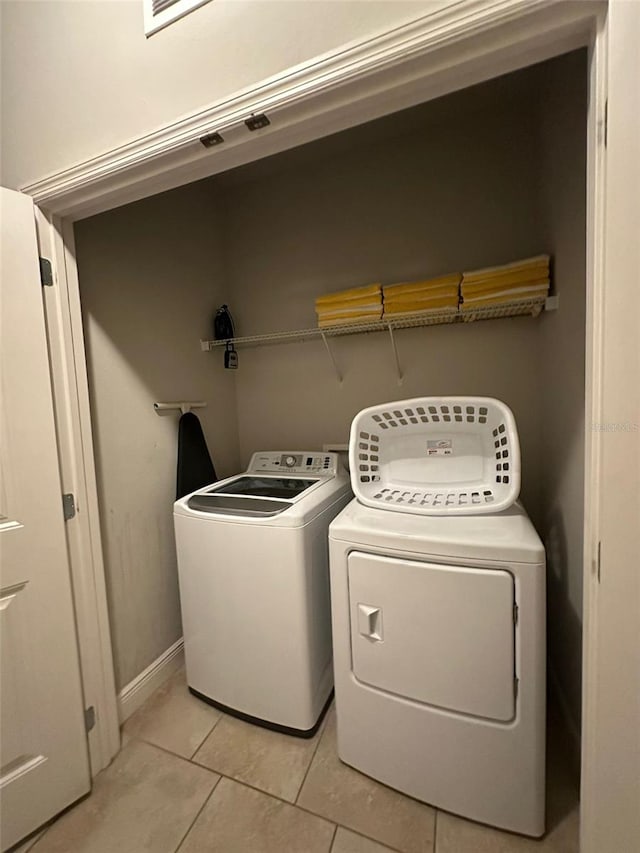 laundry area featuring light tile patterned floors and washing machine and clothes dryer