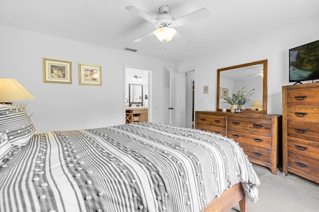 bedroom with carpet floors, ceiling fan, and connected bathroom