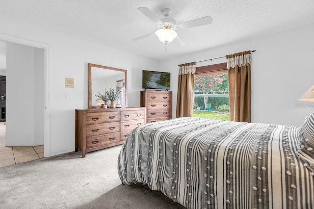 bedroom featuring ceiling fan, carpet, and a textured ceiling