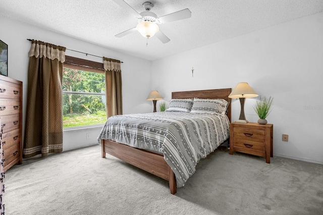 carpeted bedroom with a textured ceiling and ceiling fan