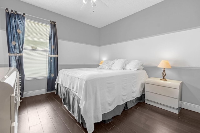 bedroom with a textured ceiling, ceiling fan, and dark hardwood / wood-style floors