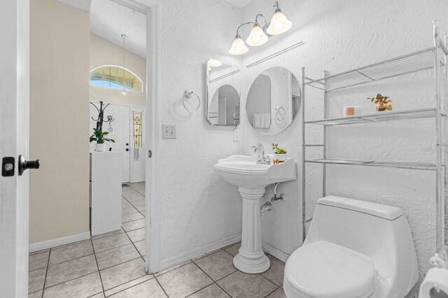 bathroom with toilet, tile patterned flooring, and a textured ceiling