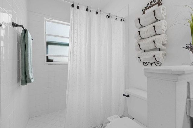 bathroom featuring toilet and curtained shower