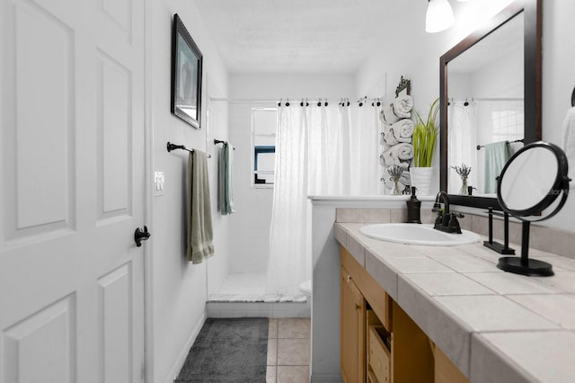 bathroom featuring toilet, a textured ceiling, tile patterned flooring, a shower with shower curtain, and vanity